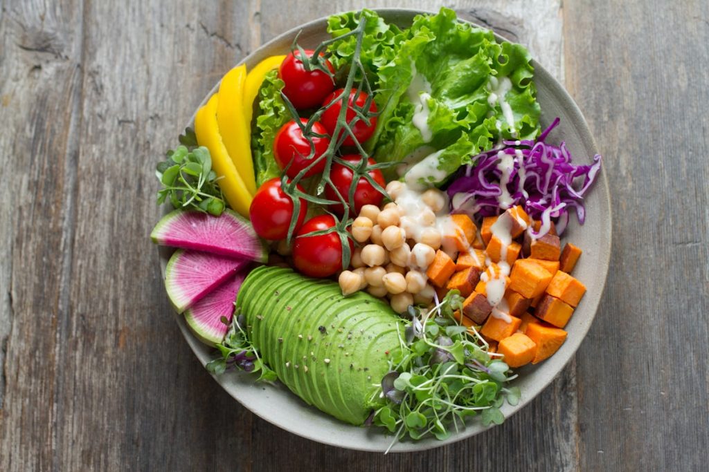 Alimentos variados como pescado, verduras y fuentes de proteína en una comida equilibrada